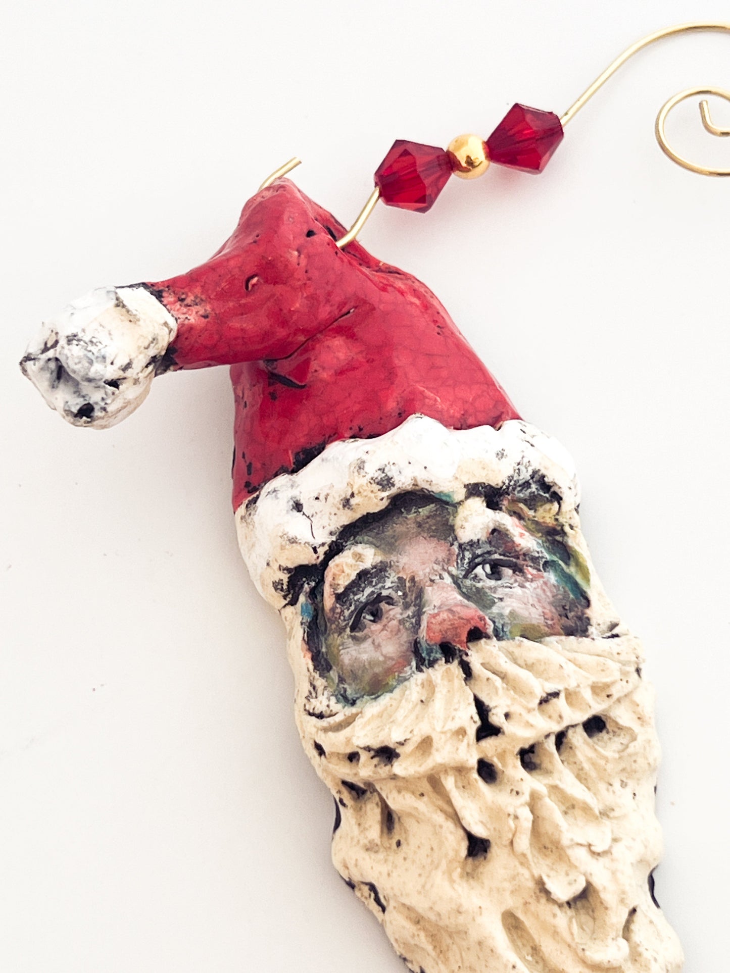 Decorative ornament shaped like a face with a Santa hat on a white background