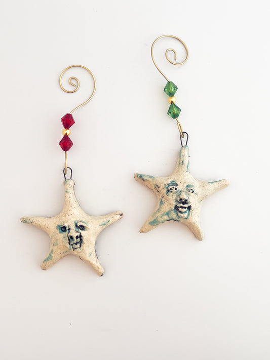 Star-shaped ceramic ornaments with decorative beads on a white background