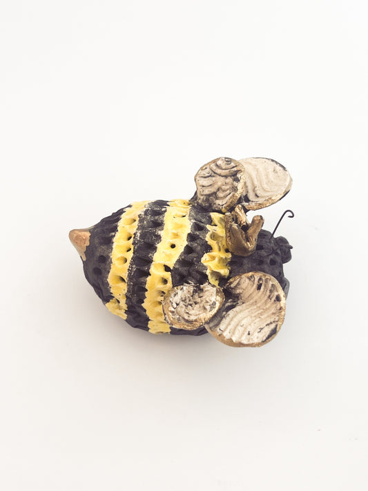 Decorative bee figure with black and yellow stripes on a white background