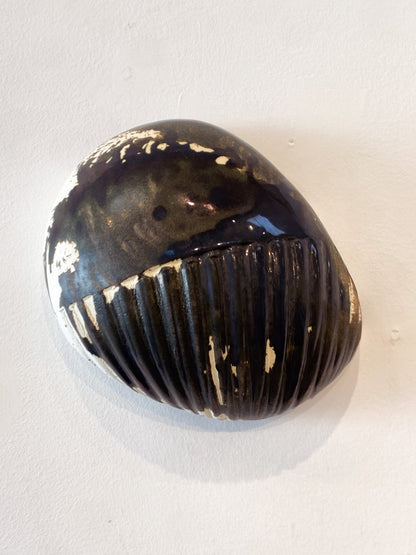 Black and gold striped object on a white background