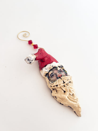 Decorative Christmas ornament shaped like a sandal with a Santa hat on a white background