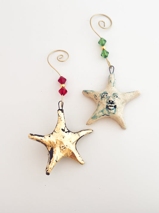 Two starfish-shaped ornaments with decorative elements on a white background