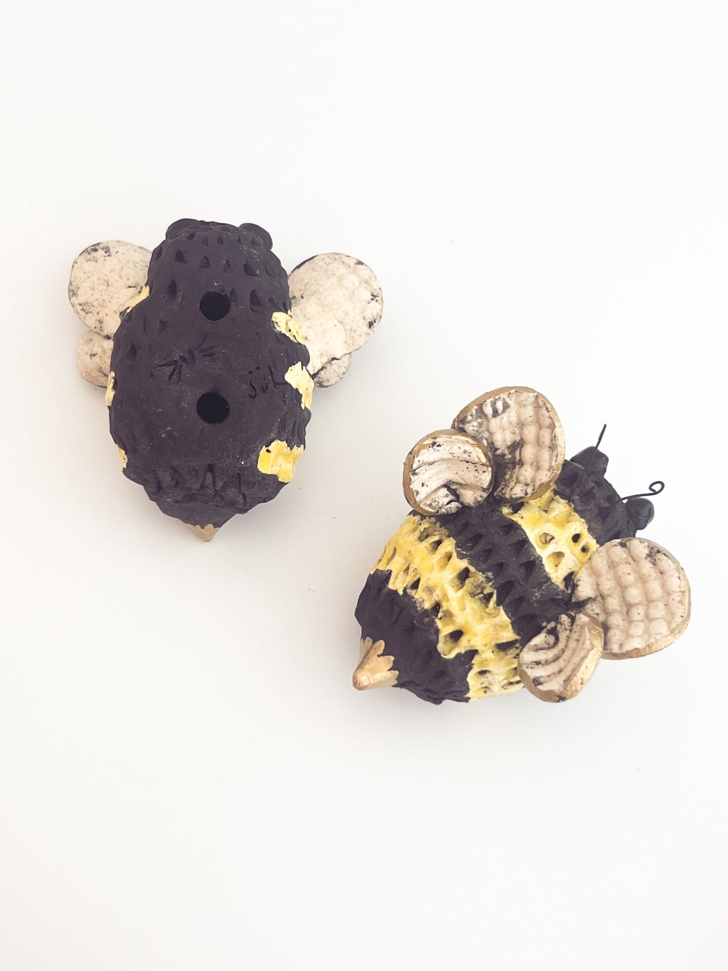 Ceramic bee wall sculptures showing front and back where you hang.