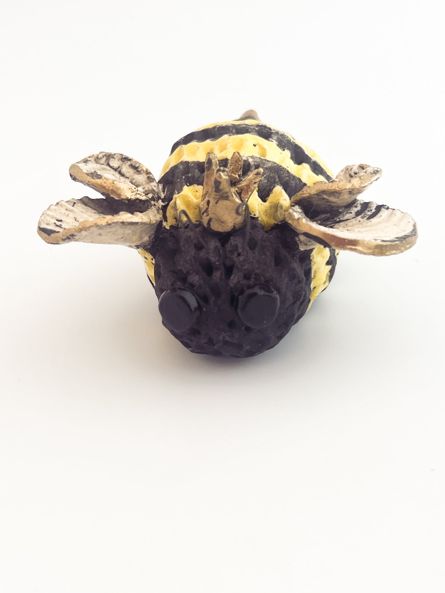 Small bee-shaped object on a white background